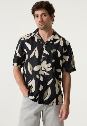 Schwarzes Kurzarmhemd mit großen cremefarbenen und olivgrünen Blättermustern, Knopfleiste, aus strukturiertem Stoff, lockerer Schnitt.