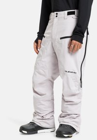 Lichtgrijze snowboardbroek van duurzaam materiaal, met ritszakken, verstevigde knieën en een verstelbare tailleband.