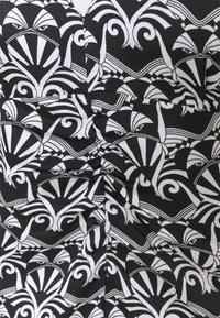 Tela negra con un patrón blanco de ojos abstractos, rayas y motivos florales, con una textura arrugada en el material.