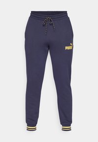 Pantalones de chándal navy hechos de una tela suave, con cintura ajustable, puños acanalados con rayas amarillas y un logo dorado de Puma.