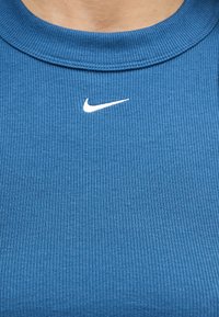 Μπλε ριπ μπλούζα με στρογγυλή λαιμόκοψη και μικρό λευκό λογότυπο Nike Swoosh τοποθετημένο κεντρικά κάτω από τη γλώσσα.