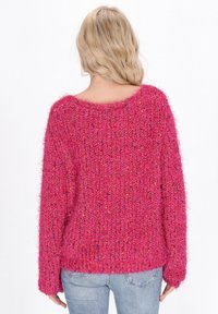 Maglione rosa morbido con una vestibilità ampia e scollatura larga, caratterizzato da un motivo a punto strutturato e maniche lunghe.