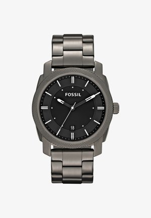 Zegarek Fossil na czarnym cyferblacie z srebrnymi oznaczeniami godzin, datownikiem o godzinie 6 i metalową bransoletą, wskazujący godzinę 10:09:36.