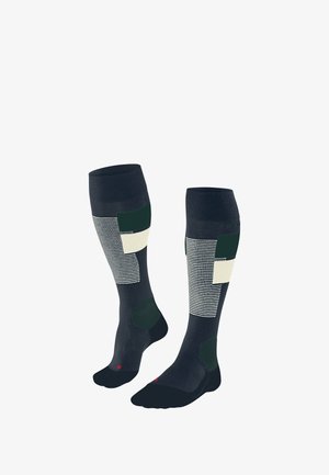 Knee-length socks in navy blue with geometric patterns in green, cream, and white. Features striped and solid segments with cushioned toe.