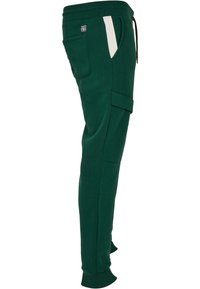 Groene trainingsbroek met zijzakken, voorzien van een witte streep detail en een trekkoord in de taille. Gemaakt van zachte katoenmix stof.