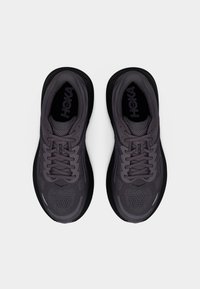 Ζευγάρι σκούρων γκρι παπουτσιών τρεξίματος HOKA με μαύρες σόλες και κορδόνια, σε θέα από πάνω σε λευκό φόντο.