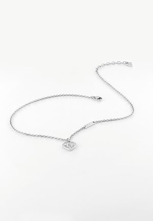 Sølvkæde med hjertevedhæng pyntet med små krystaller og en lås, lagt fladt på en hvid baggrund.