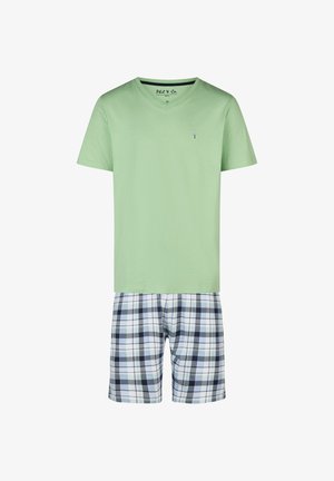 Chemise à manches courtes vert clair avec col en V, associée à un short écossais mi-long aux carreaux blancs, noirs et verts.