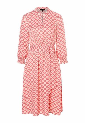 Vaaleanpunainen mekko, jossa on geometrinen valkoinen kuvio, kaulus, pitkät hihat, joustavat kalvosimet, solmittava vyö ja laskeutuva helma.