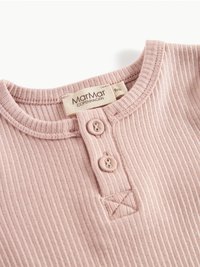 Lyserosa ribbet baby t-skjorte med rund hals, to knapper ved åpningen og en liten brodert detalj. Merket indikerer størrelse 9 måneder.