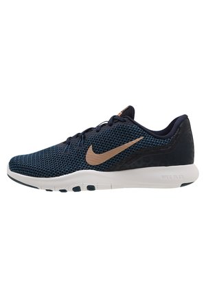 Chaussure de course Nike bleu foncé avec logo swoosh marron clair, semelle blanche flexible et tige en mesh respirant.