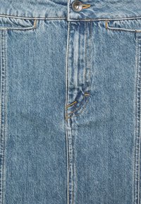 Jupe en denim avec un lavage bleu classique, dotée de coutures orange, d'une fermeture à boutons à l'avant et de poches structurées. Texture lisse et longueur mi-cuisse.