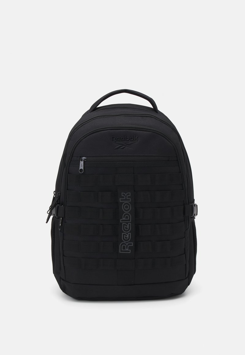 Črn nahrbtnik Reebok s gladko površino, ki ima zadrgo spredaj, oblazinjene naramnice in mrežast dizajn na sprednjem delu.