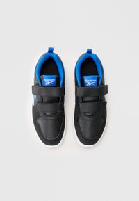 Sapatos sintéticos pretos com duas tiras de Velcro, forro azul e solas de borracha brancas. Inclui o logo da Reebok na língua.