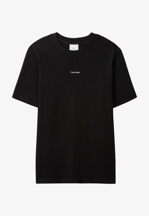 Czarny bawełniany t-shirt z okrągłym dekoltem i krótkimi rękawami. Na przodzie znajduje się małe białe logo "Calvin Klein". Gładki, klasyczny krój.