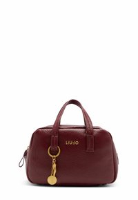 Sac à main en cuir bordeaux avec une forme arrondie, double anses supérieures, détail du logo doré et un accent de porte-clés décoratif. Surface texturée.