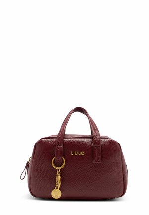 Borsa in pelle bordeaux con forma arrotondata, doppio manico superiore, dettaglio del logo dorato e un accento decorativo a chiave. Superficie testurizzata.