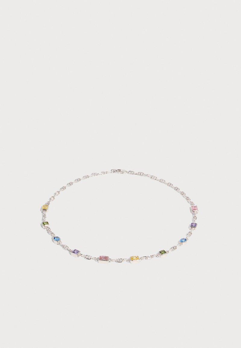 Collier en chaîne argentée avec des petites pierres précieuses rectangulaires et rondes alternées en bleu, vert, rose, jaune et violet sur fond blanc.