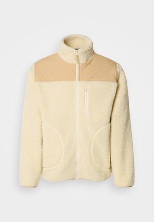 Fleece bunda v krémové barvě s horní částí z nylonu v odstínu tan, vysoký límec, plný zip a dvě boční kapsy s zaoblenými hranami.