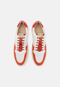 Hvite sneakers med røde suedeflater, rund tå og runde snørebånd. Logo synlig på innersålene. Glatt skinnøvre, gummisåle.