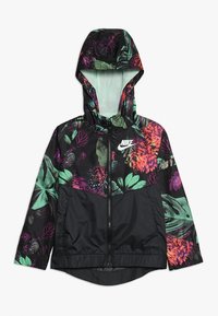 Sort vindjakke med et farverigt blomster- og bladmønster, der har hætte, lynlås og elastisk søm, lavet af letvægtsmateriale.