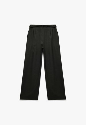Pantalons larges noirs avec une texture lisse, présentant un design ajusté et une ceinture. La taille est plissée et dispose de poches latérales.