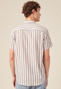 Korte mouw shirt met verticale strepen in beige en wit, gemaakt van lichtgewicht stof, met een eenvoudige kraag en een ronde zoom.