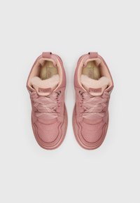 Baskets UGG roses avec un dessus doux et texturé, doublure en peluche et semelle en caoutchouc. Design à lacets avec un col rembourré.
