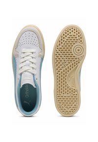 Sneakers in pelle bianca con dettagli azzurri, perforazioni e lacci rotondi. Suola in gomma con un pattern testurizzato e logo Puma.