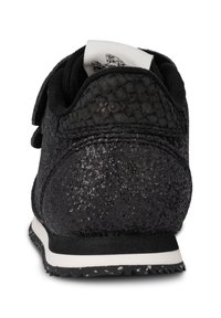 Sneaker nera con una toma superiore testurizzata con dettagli glitter, un logo bianco e una suola in gomma con un design a macchie nere e bianche.