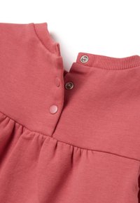 Roze katoenen jurk met een ronde halslijn, drukknoopjes aan de achterkant en een geplooide rok. Zachte textuur en eenvoudig ontwerp.