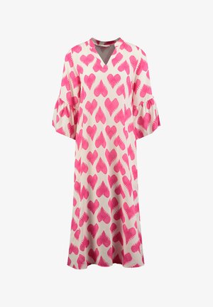 Różowa sukienka w serca, wykonana z lekkiego materiału, z dekoltem w kształcie litery V i rozszerzanymi rękawami. Tło jest w kolorze kremowym.