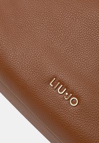 Bolso de cuero marrón texturizado con un logo en tono dorado, acabado suave y forma estructurada.