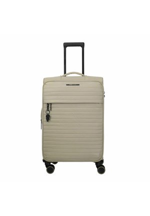 Valigia rigida beige con scanalature orizzontali, quattro ruote nere con rifiniture dorate, una maniglia superiore e un manico telescopico nero estensibile.