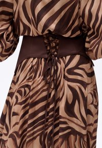 Brązowa i beżowa sukienka w zebrowy wzór, z wcięciem w talii i g�ładką, ciemnobrązową wstawką oraz detalami sznurowania z tyłu.