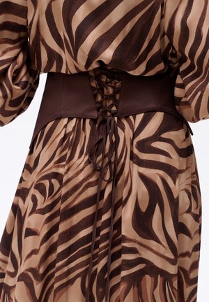 Bruine en beige jurk met een zebraprint, voorzien van een getailleerde taille met een gladde donkerbruine paneel en vetersluiting aan de achterkant.