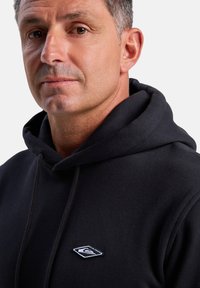 Black hoodie with a drawstring, featuring a white embroidered logo on the chest. The fabric appears soft with a smooth texture.