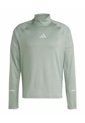 Long-sleeve athletic shirt in light green, featuring a high neck, textured fabric, and reflective accents on the sleeves. Printed logo.