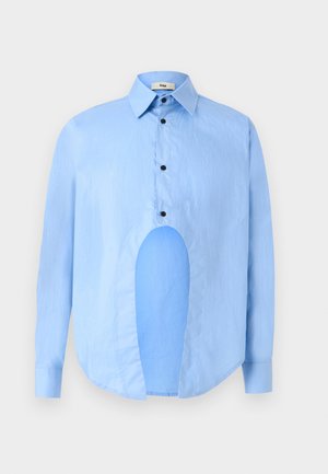 Chemise bleu clair à manches longues avec un col pointu, des boutons noirs et une découpe unique à l'avant pour un design distinctif.