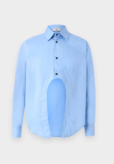 Chemise bleu clair à manches longues avec un col pointu, des boutons noirs et une découpe unique à l'avant pour un design distinctif.