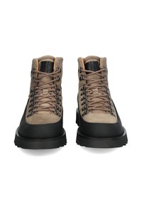 Scarponcini da trekking in pelle scamosciata marrone con suole in gomma nera, occhielli in metallo e lacci marroni. Design a caviglia alta con finitura testurizzata e collare imbottito.