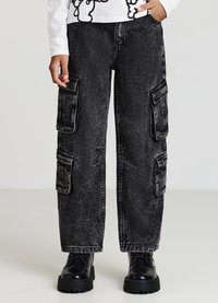 Pantaloni cargo in denim neri con una trama sbiadita, dotati di molteplici tasche laterali e un design rilassato con gamba ampia.
