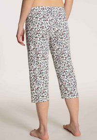 Korte broek van lichtgewicht stof met een witte achtergrond en bloemen- en loofpatronen in rood en groen, met een elastische tailleband.