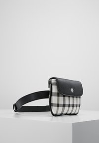 Borsa in tessuto a scacchi bianco e nero con una tracolla in pelle nera e pattina anteriore, dotata di una chiusura a scatto in argento e di una forma rettangolare compatta.