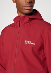 Marlowe zip-jakke med hætte, lavet af blødt stof. Har et hvidt logo på venstre bryst, glat tekstur og en tætsiddende design.
