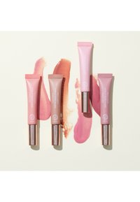 Quatre baumes à lèvres dans des teintes rose pâle et nude présentés dans des tubes avec des accents métalliques or rose, avec des échantillons des couleurs correspondantes en dessous.
