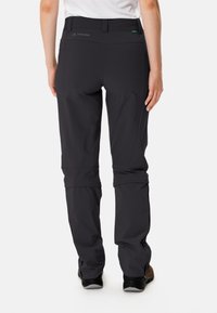 Pantaloni neri da esterno con vestibilità rilassata, orli regolabili e dettaglio del logo in vita, realizzati in tessuto leggero e resistente.