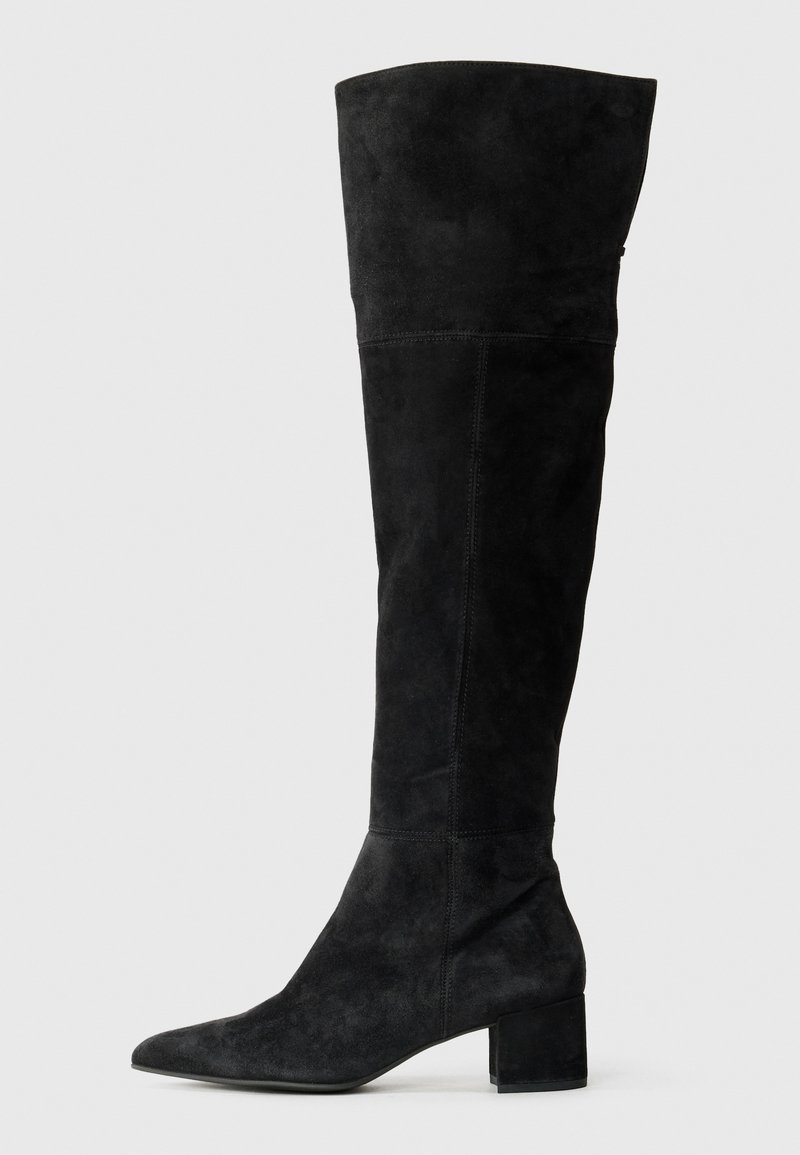 Botas negras de ante hasta la rodilla, con puntera afilada y tacón cuadrado. Textura suave con detalle de costuras verticales.