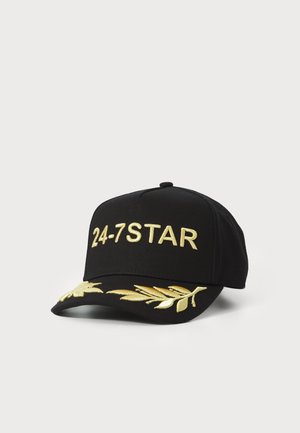 Casquette de baseball noire avec broderie dorée "24-7STAR" à l'avant et motif de feuilles dorées sur le bord. Fabriquée en tissu texturé avec une visière courbée.