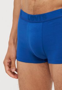 Boxers azuis feitos de um tecido suave, com uma cintura texturizada com o logótipo da Levi's. O design inclui uma forma ajustada e bordas sem costura.